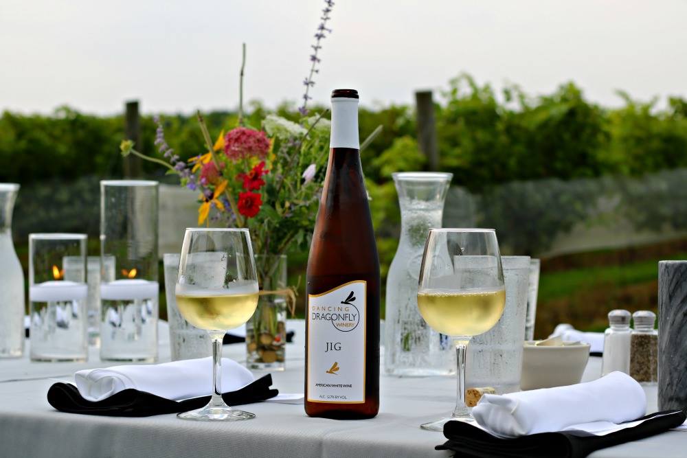 Bottle and glasses of white wine on a festive outdoor dining table
